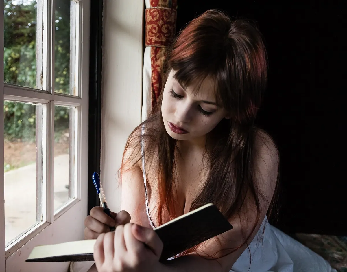 Woman at a kitchen table with a notebook, reflecting on her Enneagram test personality result